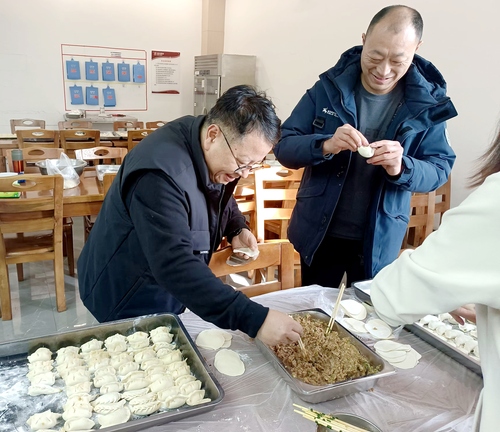 党委书记陈峻与庞献章老师包饺子